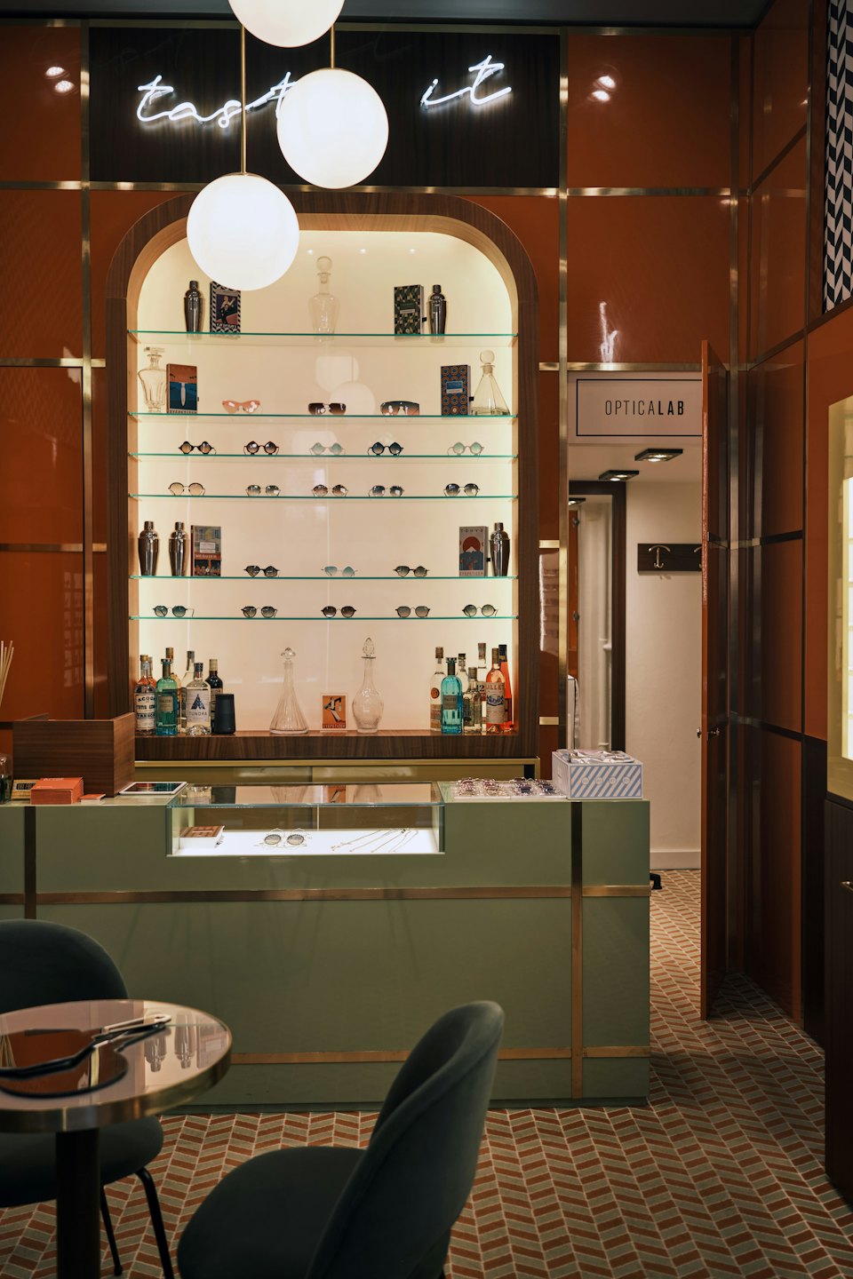 Innenansicht einer Optikerboutique mit Regalen voller Brillen und Hängelampen.